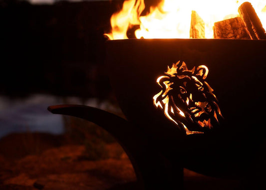 The Big Five Stainless Steel Fire Pit, Displaying the lion cutout, with a roaring flame.