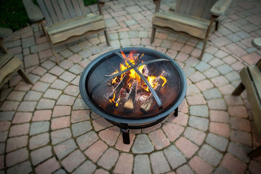 Brushed Copper Wood Burning Outdoor Firebowl, positioned in the center of the outdoor patio, with wood burning and a warm flame