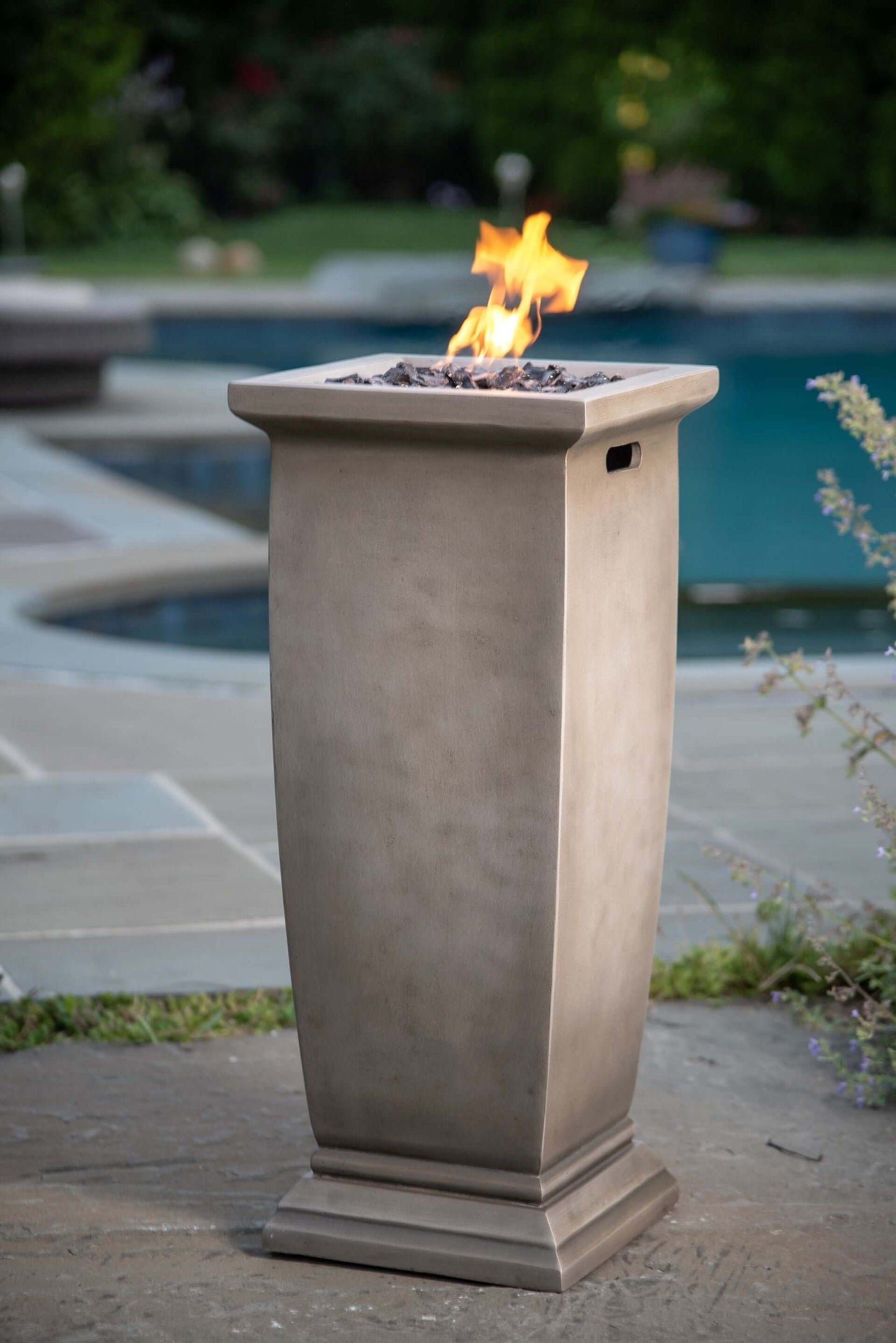 The 28 X 11 inch MGO Gas Outdoor Fire Pit, displayed on a poolside patio, with a warm flame.