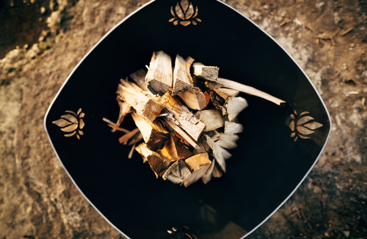 The gorgeous Namaste Fire Pit, Displayed from a top down angle, showcasing its huge fire bowl, full of wood.