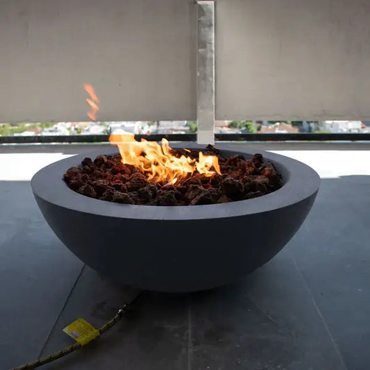 The Venecia Concrete Fire Bowl 02 Displayed in the Graphite color option, on a balcony.