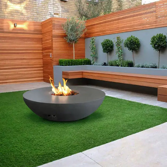 The Venecia Concrete Fire Bowl 07 displayed in the graphite color option on a Backyard patio.