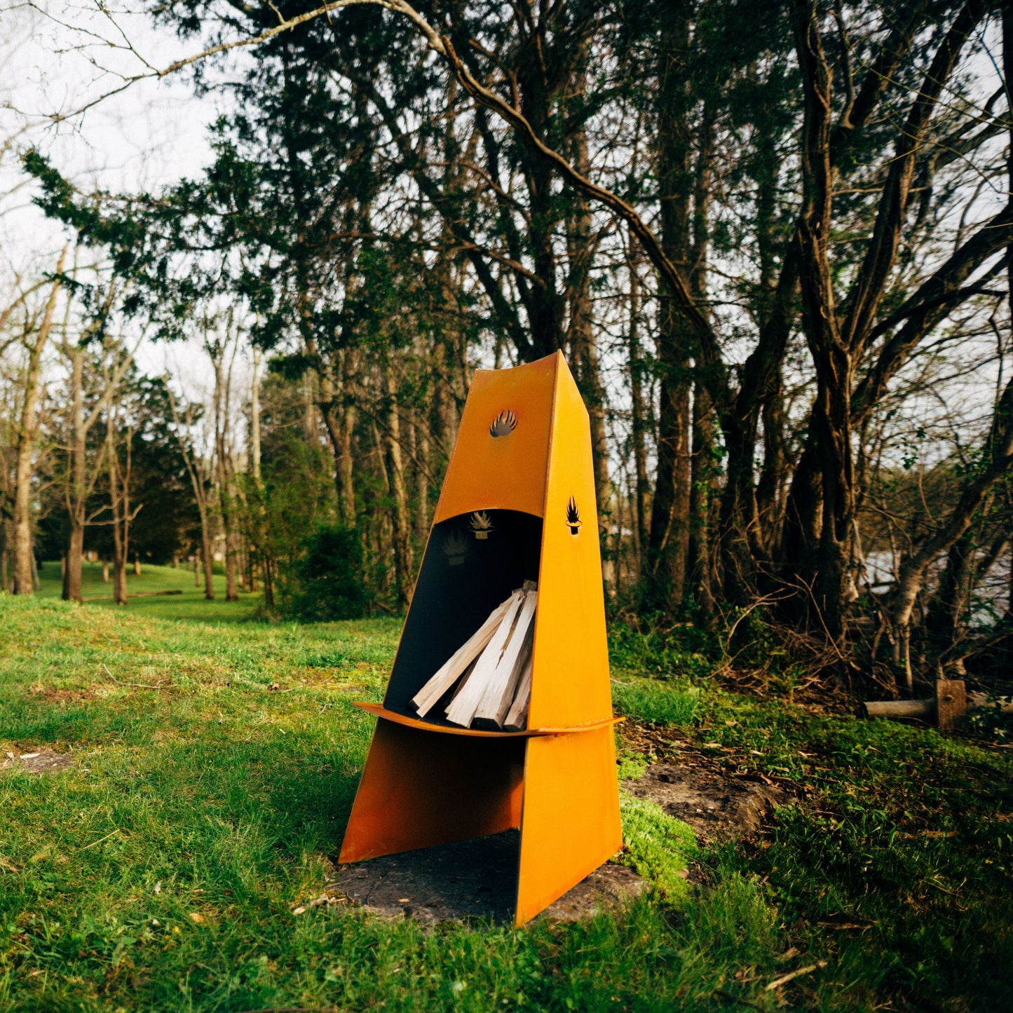 The Vesuvius wood burning fire pit, Displayed in a grassy green backyard.