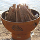 The BeachComber Fire Pit, displayed on the lake shore, full of fire wood.