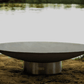 The Bella Vita Series Fire Pit, Displayed on the sandy beach of a lake.