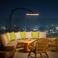 Outdoor evening setting with a sofa, chairs, and table on a rooftop with city lights in the background, using the Modern Black Bromic Portable Outdoor Heater.