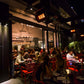 People dining at tables outside a restaurant at night, with the bromic gas patio heater giving off heat.