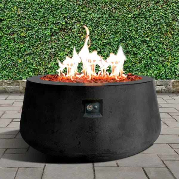 The Indiana Modern Fire Pit 02. Showcased in the Noir color option with a warm flame, on a outdoor patio.