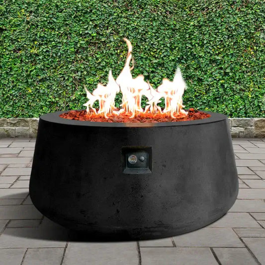 The Indiana Modern Fire Pit 02. Showcased in the Noir color option with a warm flame, on a outdoor patio.