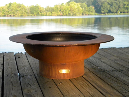 The Handcrafted Saturn fire pit displayed on a lakeside dock.