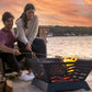  The Patriot Wood Burning Fire Pit on  a oceanside beach, with two people roasting marshmallows.