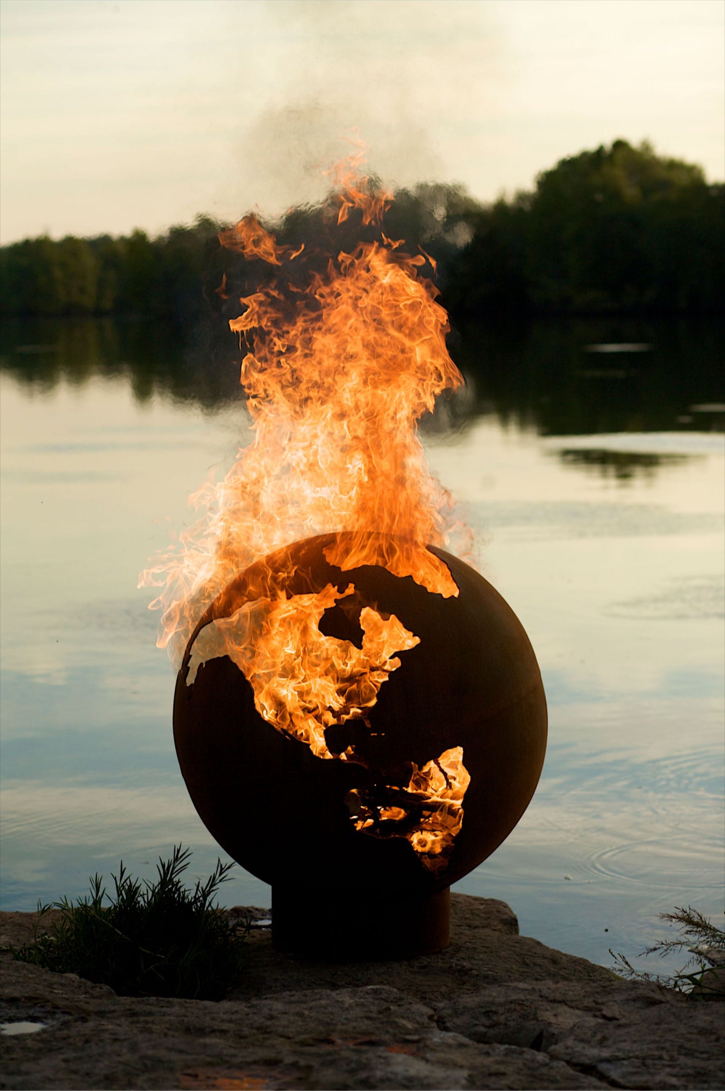 The Third Rock Fire Pit, Displayed on a lakeside rock with a huge flame.